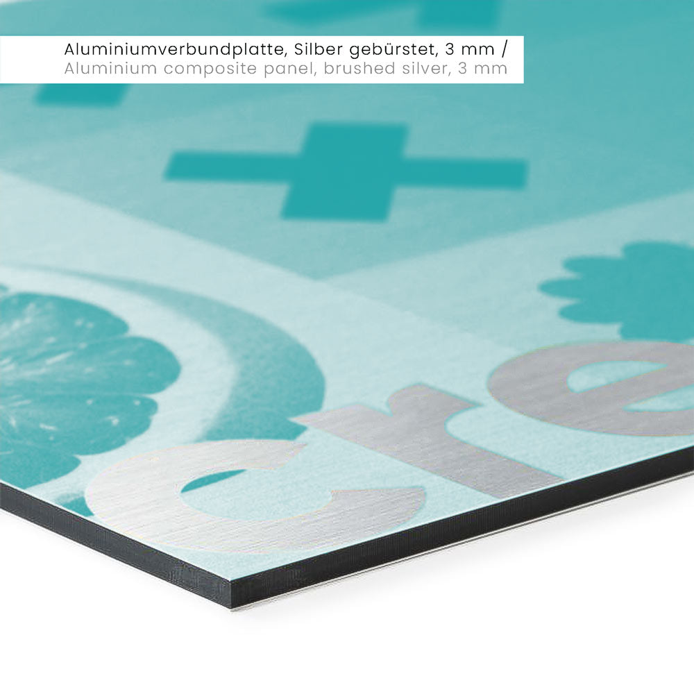 Nahaufnahme eines Materials mit einer türkisfarbenen Grafik, auf der Zitrusfrüchte und das Wort "create" in silberner Farbe zu sehen sind. Die Kante des Materials ist schwarz und der Blickwinkel zeigt eine scharfe, klare Kante.