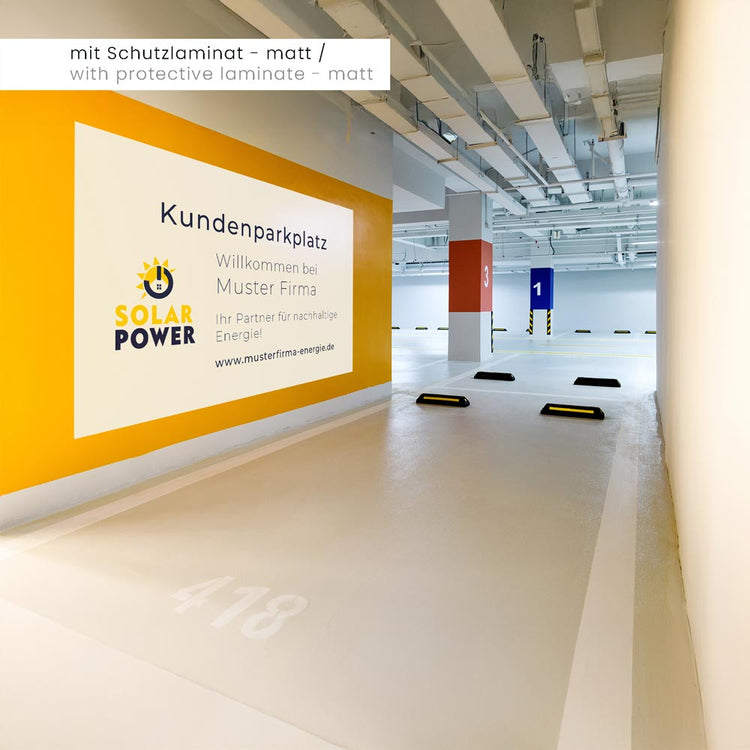 Aufkleber mit grauer Rückseite, überdeckt selbst bunte, gelbe Wände. Hier als Werbung in einem Parkhaus mit mattem Schutzlaminat.