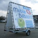 Ein mobiles Werbeplakat auf einem Anhänger. Es zeigt eine große Werbefläche mit dem Text „Te Huur Mobile Billboard“ und Informationen zum Preis und der Größe des Werbeplakats.