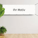 Individuelles Banner mit dem Schriftzug "Ihr Motiv" auf weißem Hintergrund, gespannt an einer Wand, bereit für die Personalisierung nach Wunsch.