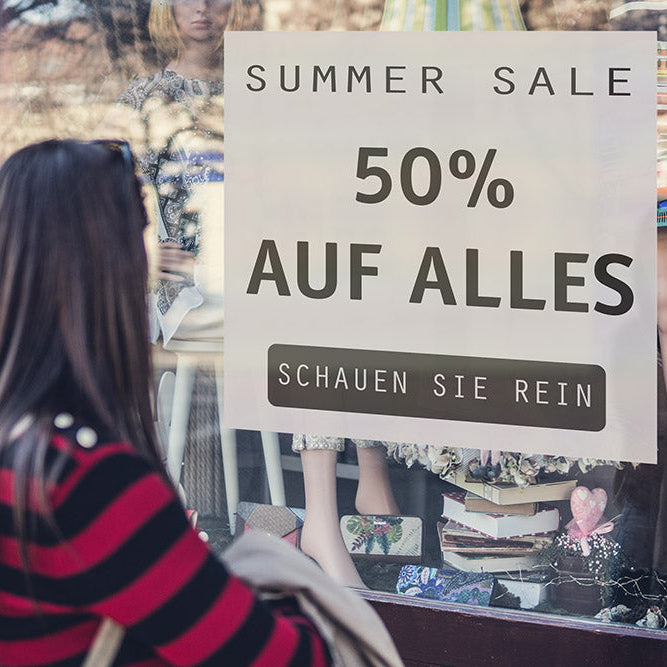 Anwendung des Bubble Free Aufklebers an einer ebenen Schaufensterscheibe. Für kurzfristige Saison Artikel und Sales Angebote.