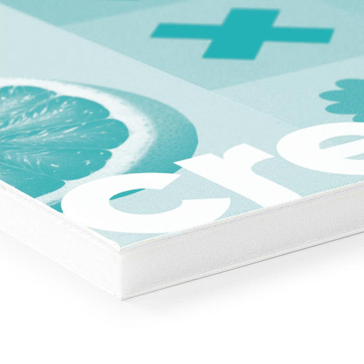 Nahaufnahme eines weißen Kunststoffmaterials, das eine türkisfarbene Grafik mit einem Zitronenmuster und dem Wort "create" zeigt. Die Kante des Materials ist klar erkennbar und hat eine schlichte, saubere Erscheinung.