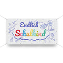 Einschulungs-Banner mit der Aufschrift „Endlich Schulkind“ auf weißem Hintergrund mit kariertem Muster, verziert mit bunten Buchstaben und Schulmotiven wie Rakete, Buch und Papierflieger.