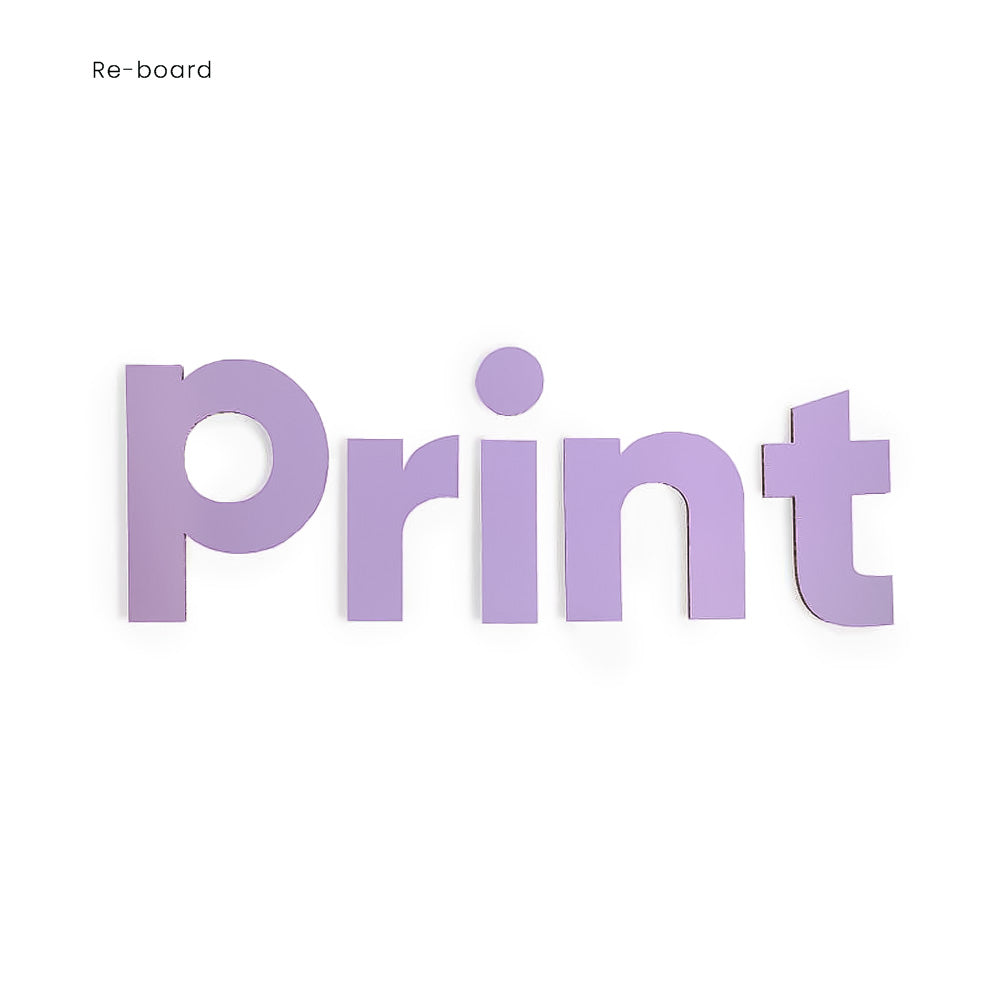 Das Bild zeigt Fräsbuchstaben aus Reboard Pappe in lila. Die Buchstaben bilden das Wort "Print", wobei die Seitenansicht der Wellpappe an den Rändern der Buchstaben sichtbar ist.