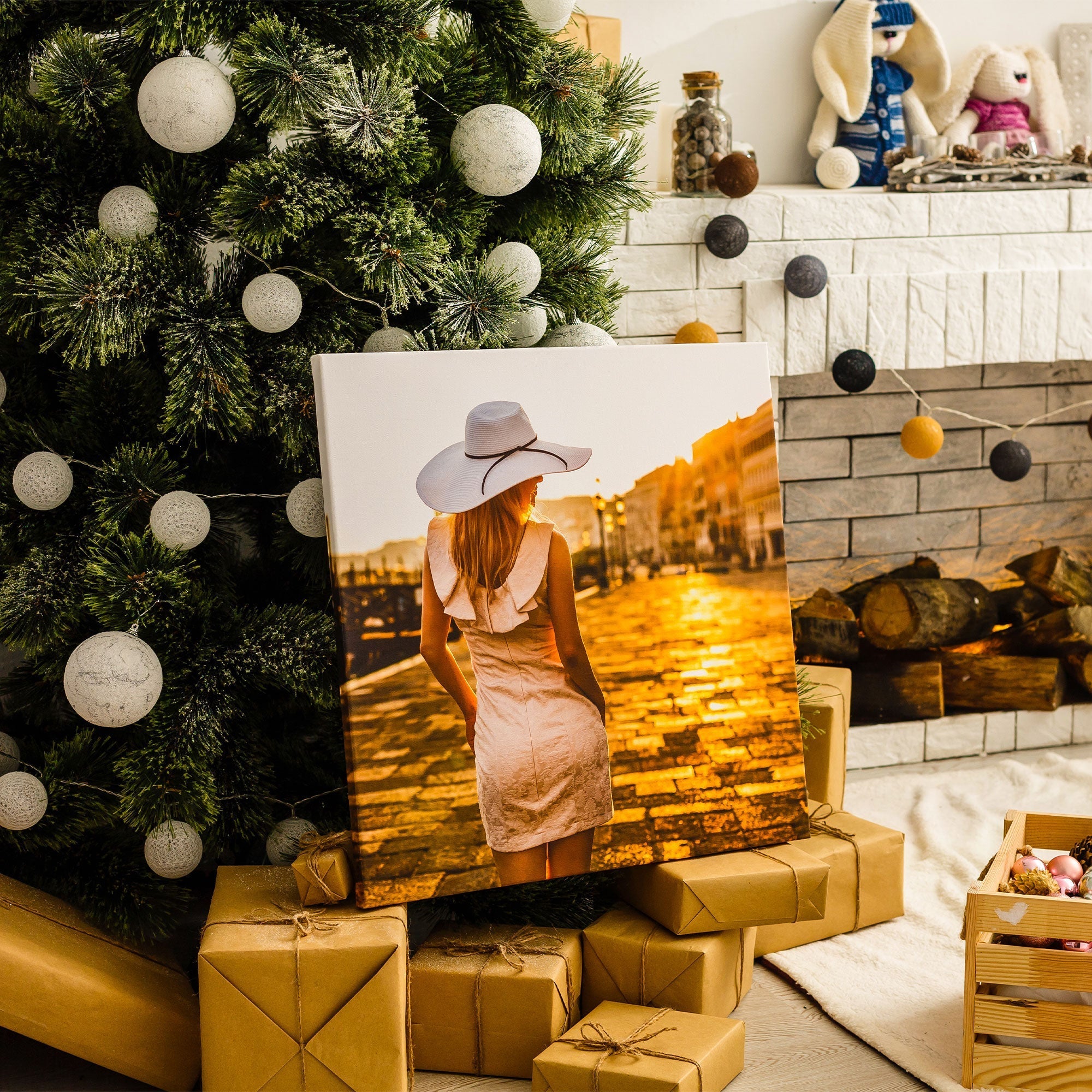Stilvolles Leinwandbild mit einer Frau im Sonnenuntergang als besonderes Weihnachtsgeschenk, dekorativ unter einem geschmückten Weihnachtsbaum mit verpackten Geschenken arrangiert.