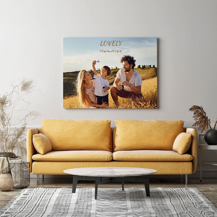 Personalisierte Leinwand mit einem Familienfoto und dem Schriftzug „Lovely Memories“, stilvoll über einem gelben Sofa im Wohnzimmer dekoriert.