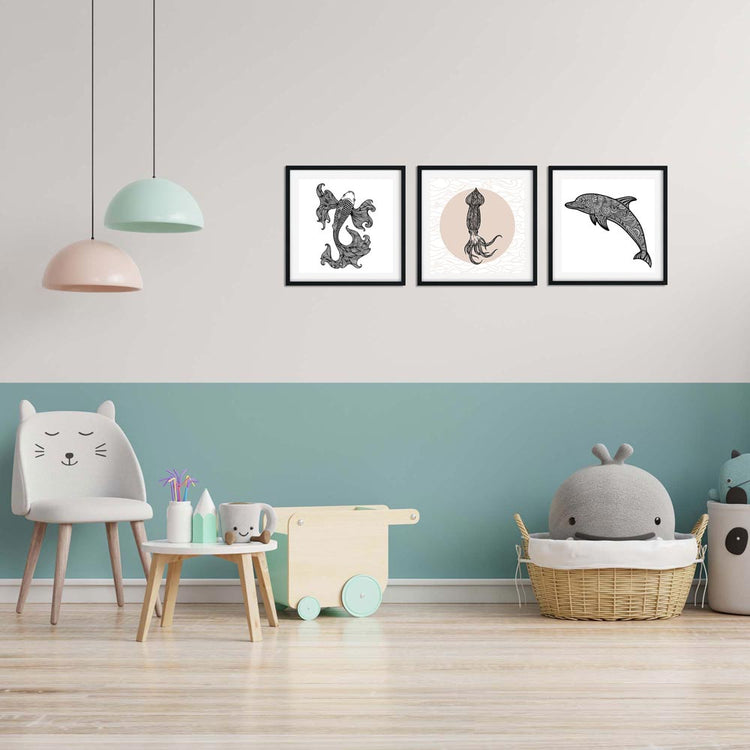 Drei Wandbilder mit einem Oktopus, einem Wal und einem Delfin in schwarz-weißen Illustrationen hängen an einer Wand im Kinderzimmer. Der Raum ist modern eingerichtet mit einem Spielzeugwagen und einem großen Stoffwal.