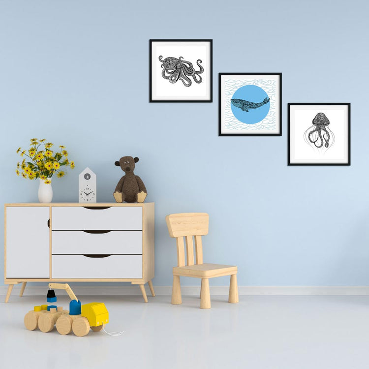 Meeresbewohner-Drucke in einem Kinderzimmer, bestehend aus einem Oktopus, einem Wal und einer Qualle an der Wand, neben einem Spielzeug.