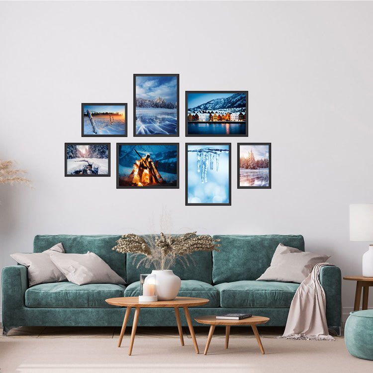 Poster-Collage mit winterlichen Landschaften und verschneiten Orten – stimmungsvolle Wanddeko im Winter-Design. Das sind die Rückansichten von dem Winter-Set, als Dekoidee in schwarzen Rahmen an einer weissen Wand über einer grünen Couch.