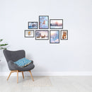 Poster-Collage mit winterlichen Naturmotiven: Vögel, Rehe, Fuchs, Eichhörnchen und verschneite Landschaften – stimmungsvolle Wanddeko im Winter-Design. Das sind die Vorderansichten von dem Winter-Set, als Dekoidee in schwarzen Rahmen an einer weissen Wand neben einem grauen Sessel.