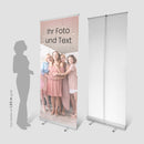 RollUp Aufsteller zum Selbstgestalten mit eigenen Fotos und Texten, Vorder- und Rückansicht vom System, neben einer Schatten-Person als Größenvergleich. Hier mit einem Druck von einer Babyshower Party.