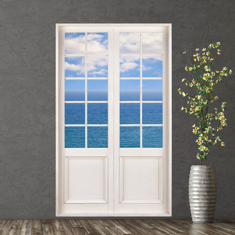 Selbstklebende Terrassentür-Aufkleber mit Urlaubsmotiv auf das Meer mit Wolken für einen Tiefe im Raum. An einer grauen Wand neben einer Bodenvase verklebt.