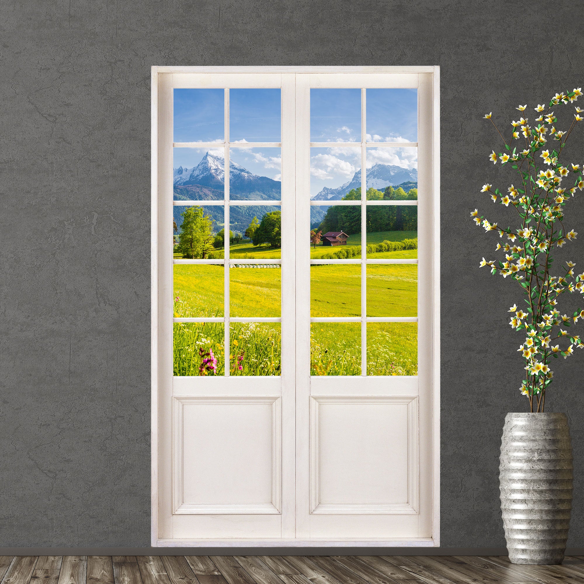 Selbstklebende Tapete mit Terrassentür für Ausblick auf idyllische Natur, Motiv: Alpenblick mit grüner Wiese. Als Dekoidee an einer grauen Wand verklebt, neben einer Bodenvase. 