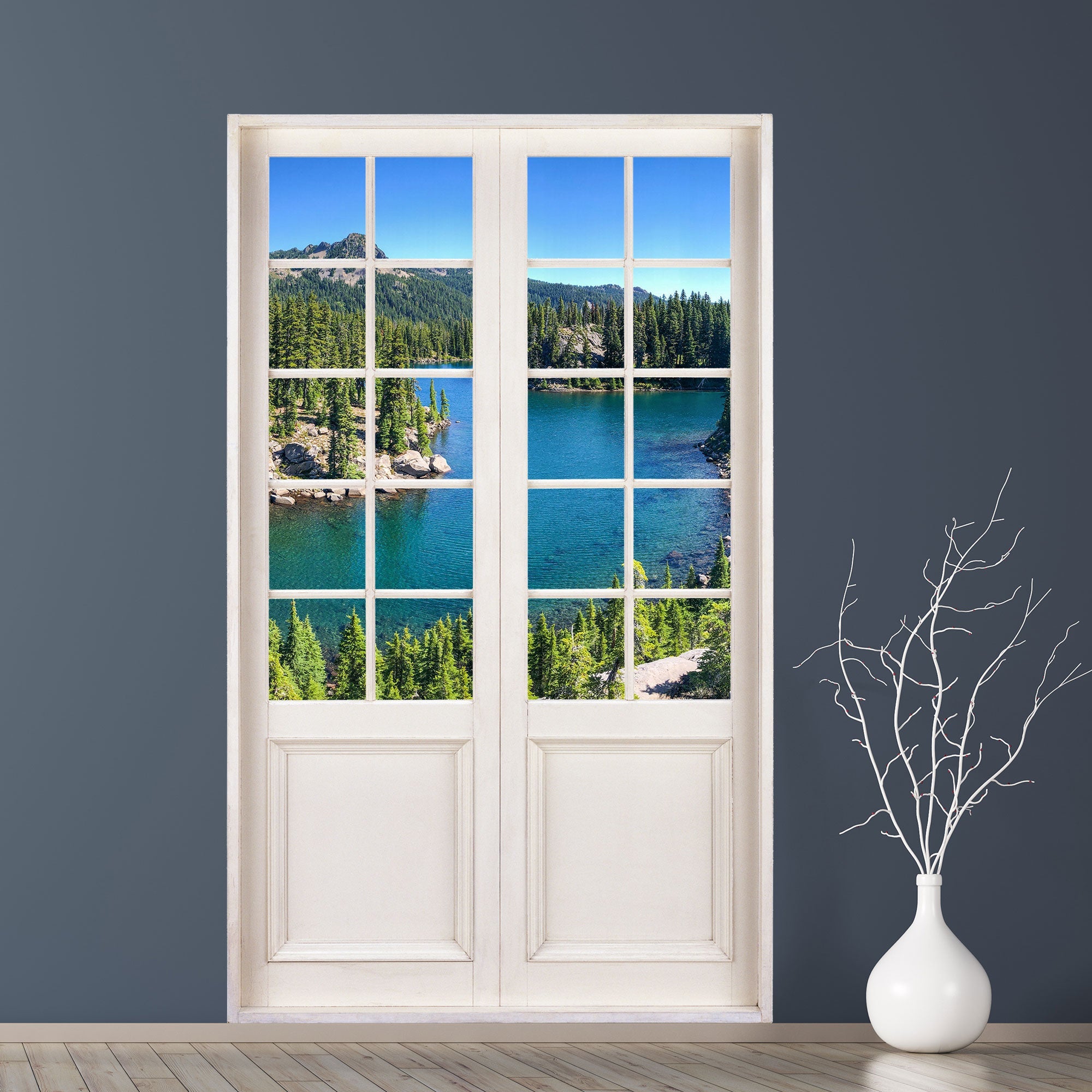 Selbstklebende Wandtapete als Terrassentür, mit tollem Ausblick auf einen Bergsee mit Wald. Als Beispiel an einer dunkel grauen Wand neben einer Bodenvase verklebt.