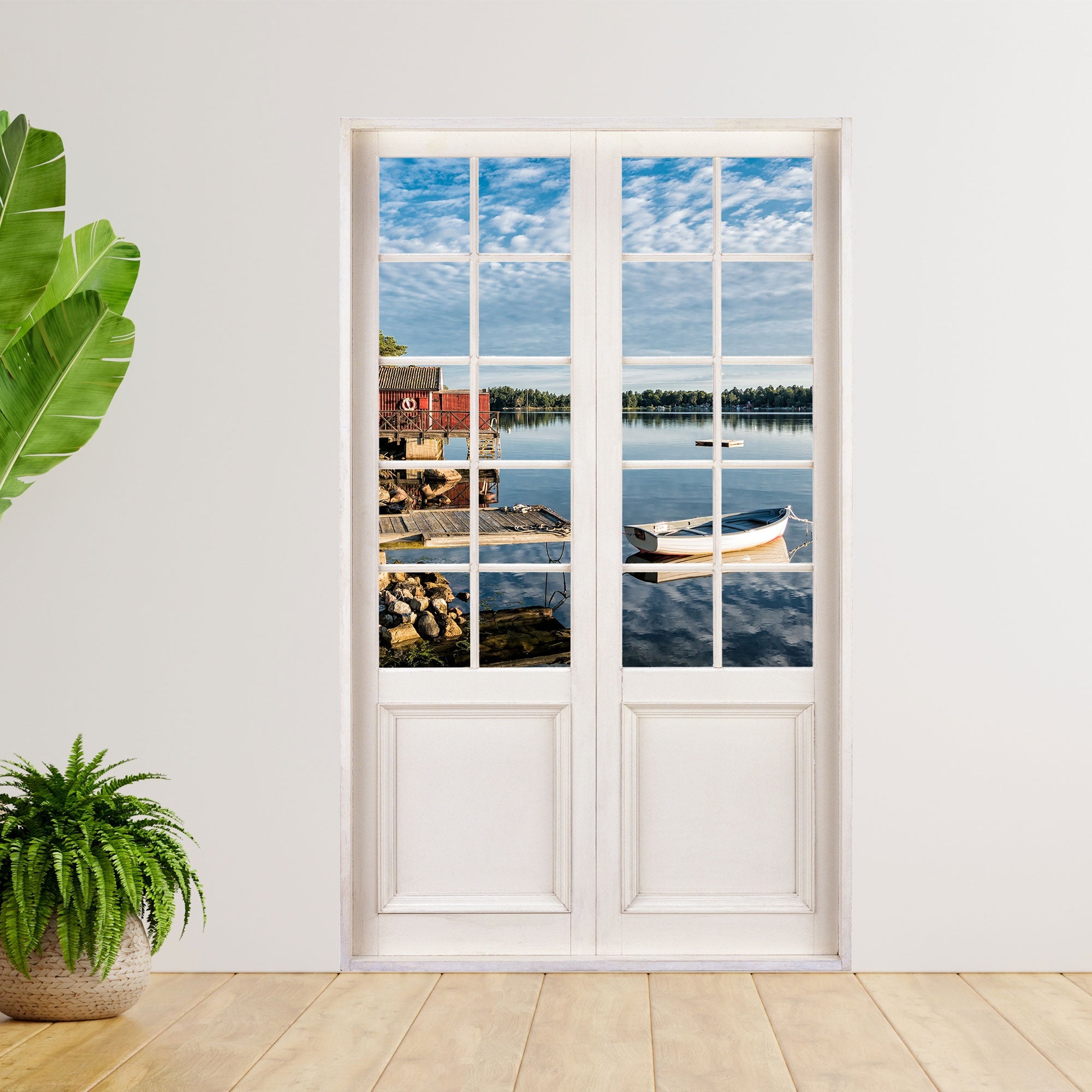 Selbstklebende Terrassentür mit Urlaubsmotiv der Schwedischen Küste, mit einem Boot und rotem Haus. An einer weissen Wand neben Zimmerpflanzen verklebt.