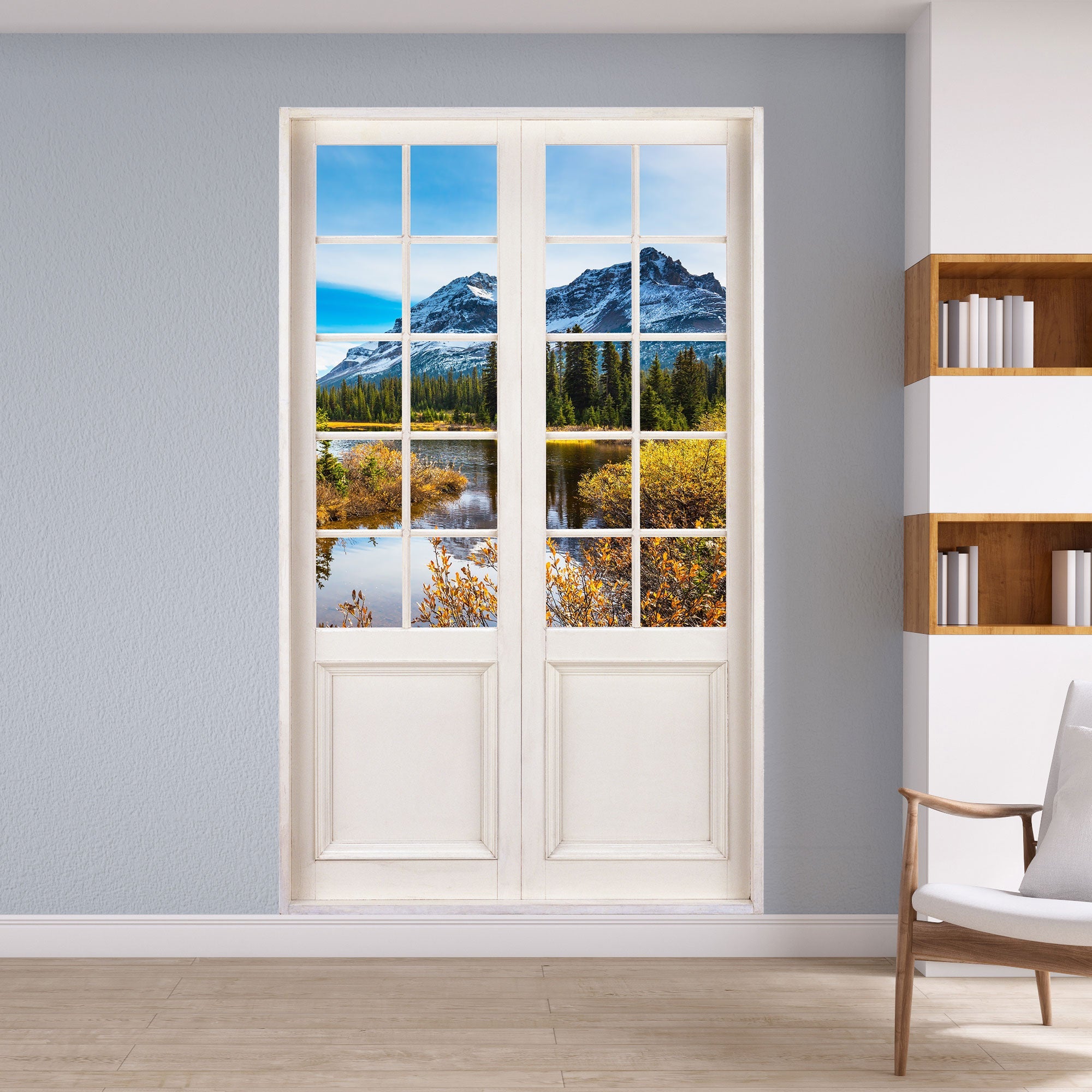 Foto einer Terrassentür gedruckt als Wandaufkleber mit Urlausbmotiv auf eine Alpenlandschaft mit einem See und  einem grünen Wald. An einer grauen Wand neben einem Bücherregal verklebt.