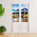 Wandaufkleber einer Glastür mit Sprossenfenster und Blick auf Berg und Fluss für Schlaf- und Gästezimmer. Als Größenbeispiel an einer Wand neben großen Zimmerpflanzen verklebt.