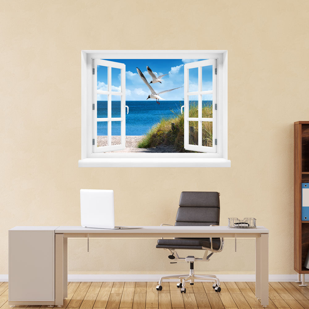 Kleine Auszeit zum LIeblingsort, erholsames Wandbild, selbstklebend mit Blick aus einem gedrucktem Fensterrahmen mit Ostseebild "Strand mit Möwen" über einem Büro Tisch an einer gelben Wand.