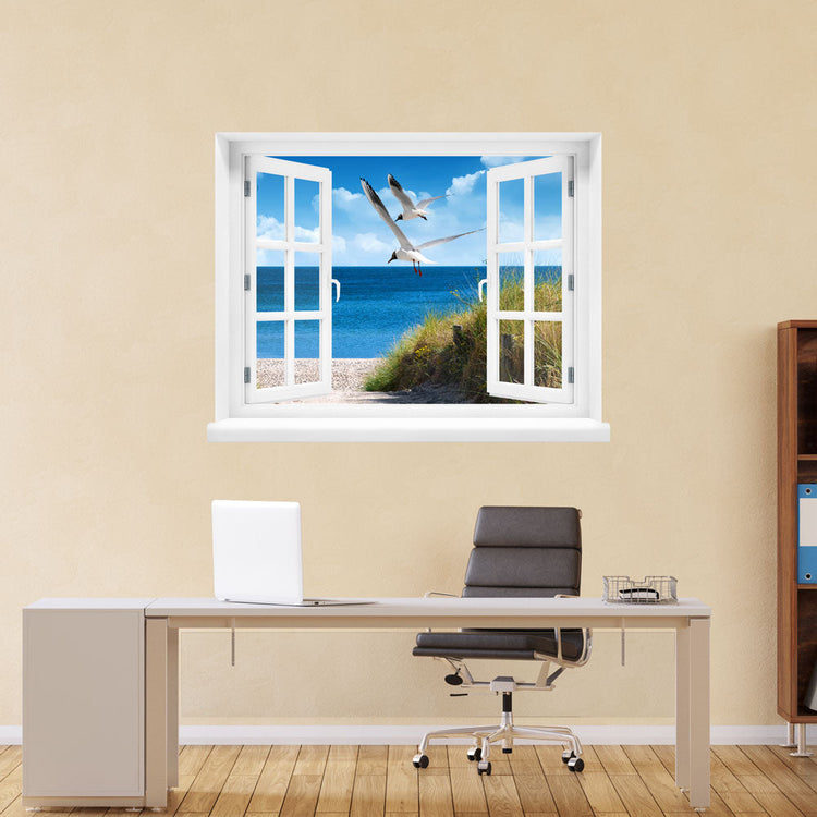 Kleine Auszeit zum LIeblingsort, erholsames Wandbild, selbstklebend mit Blick aus einem gedrucktem Fensterrahmen mit Ostseebild "Strand mit Möwen" über einem Büro Tisch an einer gelben Wand.