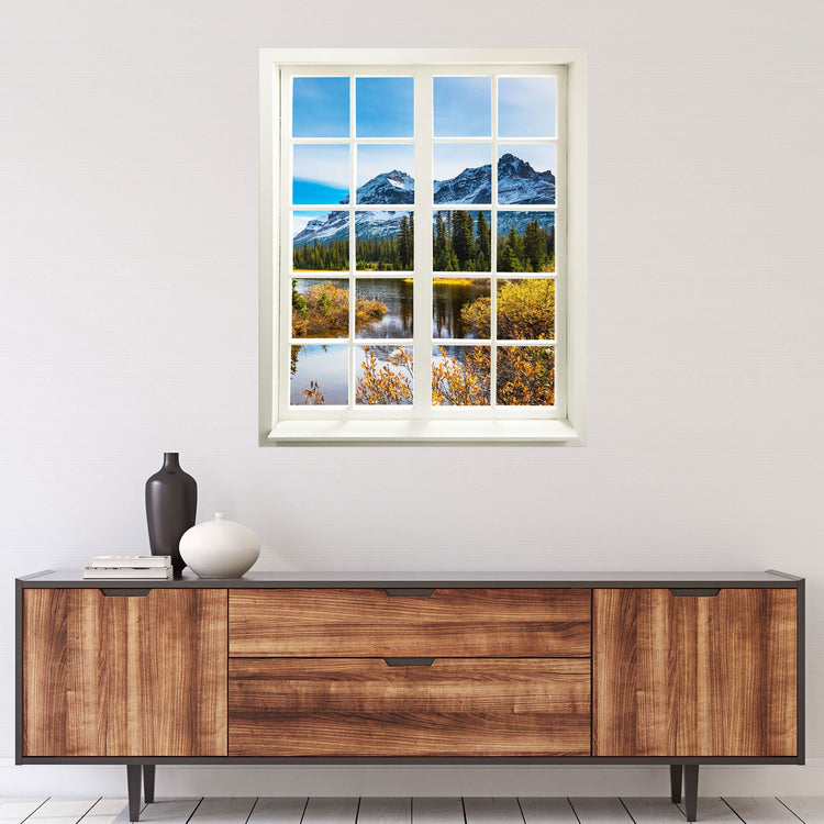 Wandaufkleber Fensterblick, selbstklebend mit erholsamer Aussicht auf Berge, Fluss und einem Tannenwald. An einer Wand über einer Holz-Kommode.