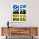 Hingucker für dunkle Räume oder ohne Fenster, selbstklebendes Wandtattoo als gedruckter Fensterrahmen mit tollem Ausblick "Berge und Wildblumen" über einer Holz-Kommode.