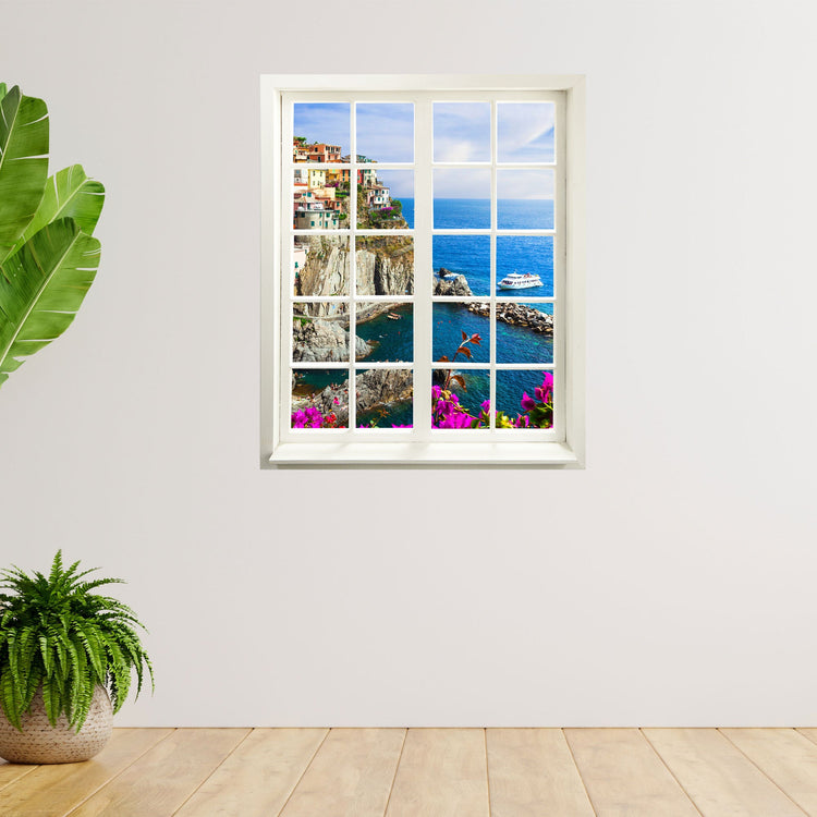 Hingucker für dunkle Räume oder ohne Fenster, selbstklebendes Wandtattoo als gedruckter Fensterrahmen mit tollem Ausblick auf ein buntes Dorf "Cinque Terre" an einer weissen Wand neben Zimmerpflanzen.
