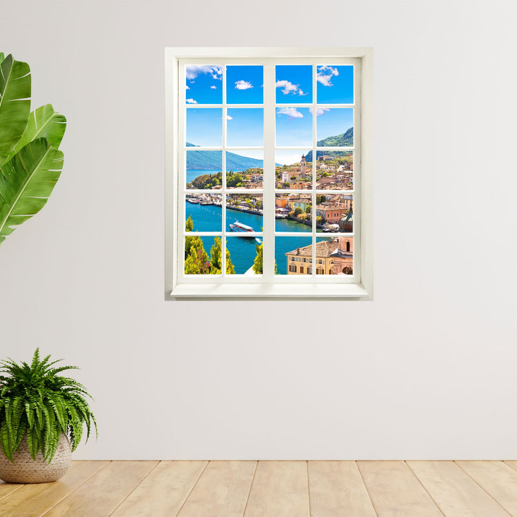 Innendekoration für Wartezimmer und Flur, der Fensterblick-Aufkleber mit dem Motiv "Dorf am See" ist an einer freien Wand neben Zimmerpflanzen verklebt.