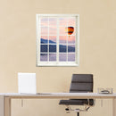 Gedrucktes Foto für Wände und Möbel, mit einem Sprossenfenstermotiv und Blick auf einen fliegenden Heißluftballon über einer Berglandschaft. An einer gelben Wand über einem Schreibtisch.