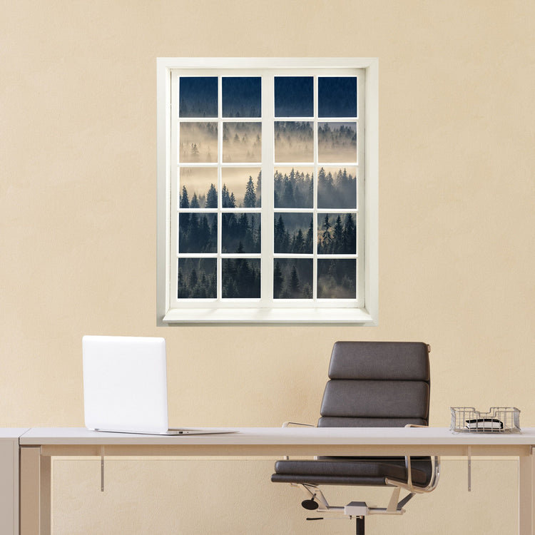 Wandtattoo Fensterblick "Nebelwald" hinter dem Bürotisch an einer gelben Wand verklebt.