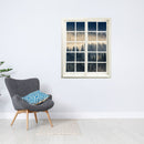 Wandtattoo Fensterblick "Nebelwald" in moderner Leseecke über einem grauen Sessel.
