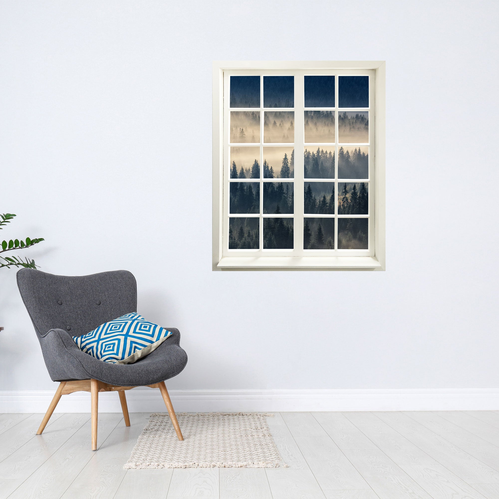 Wandtattoo Fensterblick "Nebelwald" in moderner Leseecke über einem grauen Sessel.