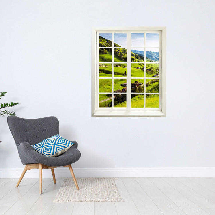 Wandtattoo - Fensterblick "Schwarzwald" neben einem grauen Sessel.