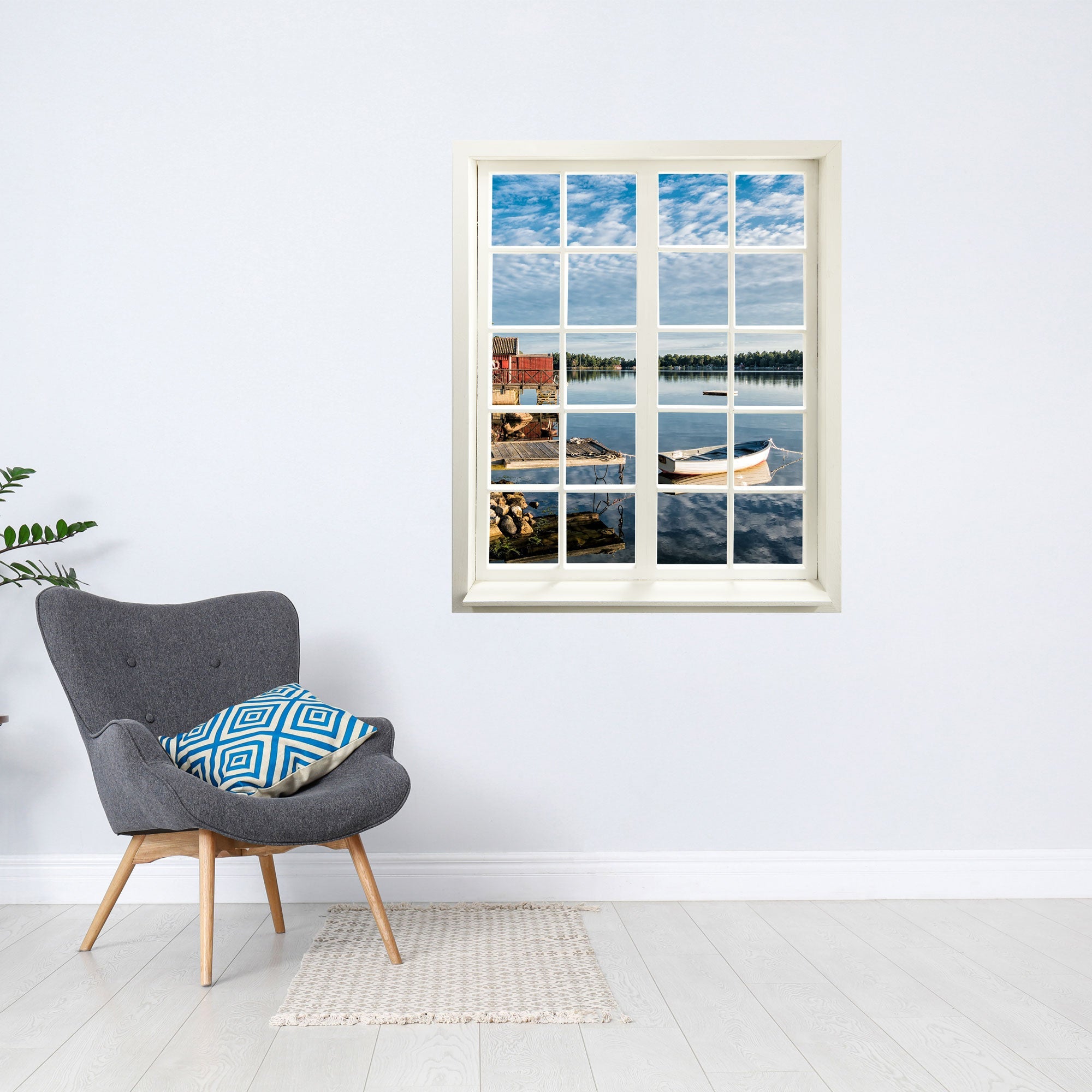 Wandaufkleber Sprossenfenster geschlossen, mit toller Aussicht auf ein Seeufer mit Steg und Boot, vergrößert Zimmer optisch für Flure und Gästezimmer. Als Beispiel hier an der Wand über einem grauen Sessel.