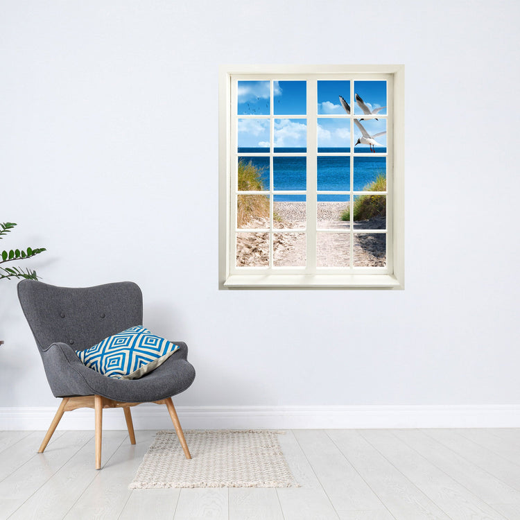 Wandtattoo Motiv Fensterblick "Strand mit Möwen" neben grauem Lesesessel.