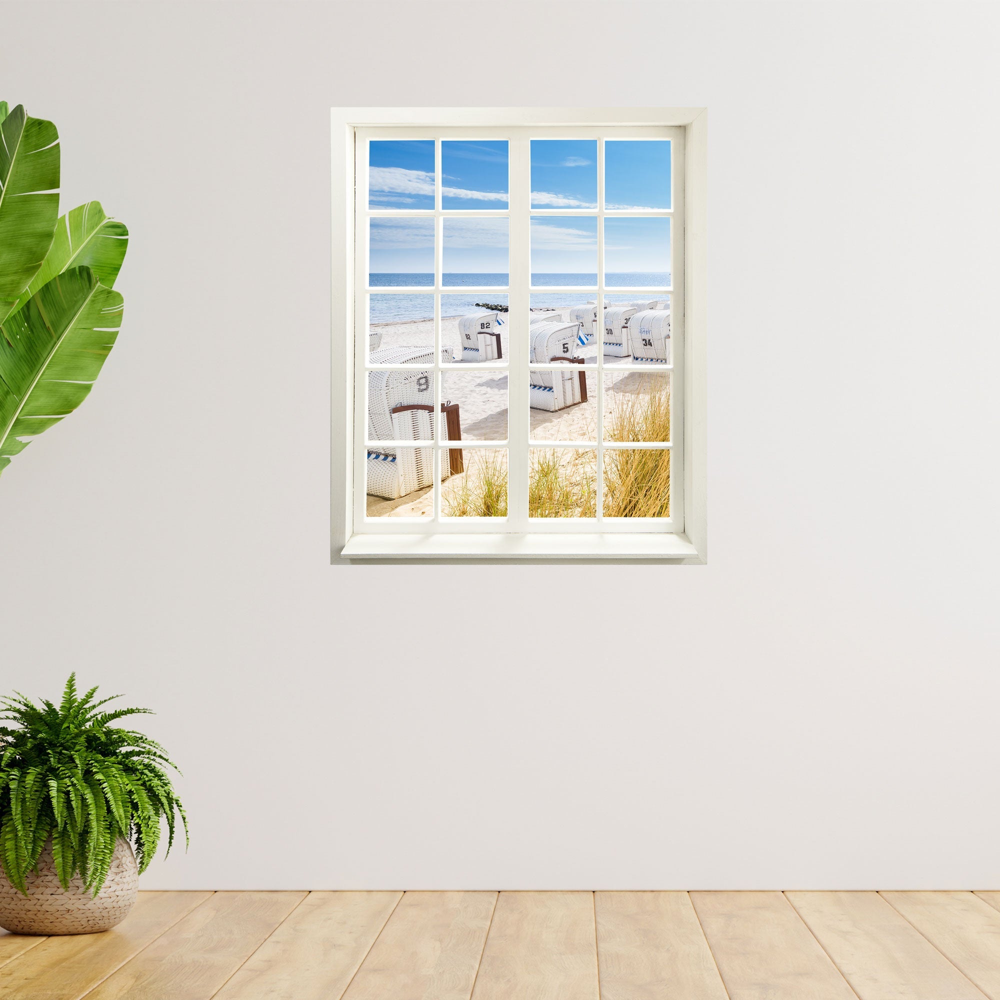 Wandtattoo Fensterblick "Strandkörbe Ostsee" an heller Wand neben Zimmerpflanzen verklebt.