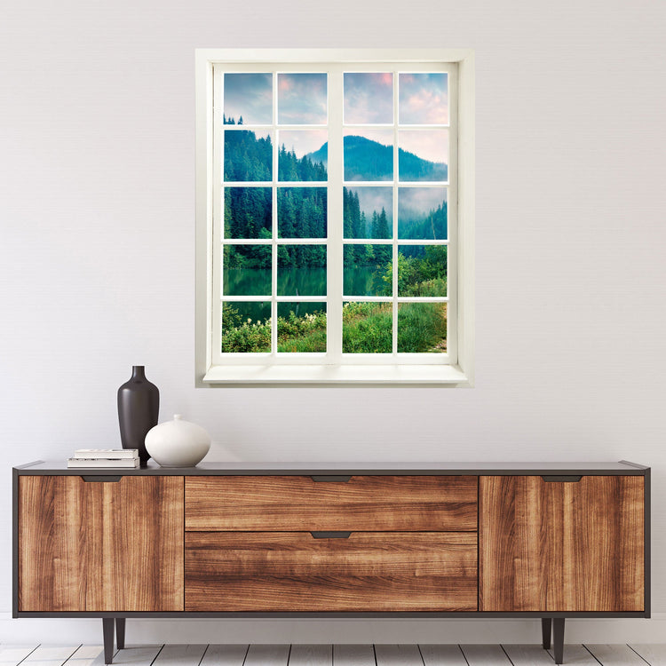 Selbstklebende Wandaufkleber-Bild für Flur, Bad oder Wohnzimmer. Der Fensterblick-Aufkleber mit dem Motiv "Tannenwald am See" über einer Holz-Kommode verklebt.