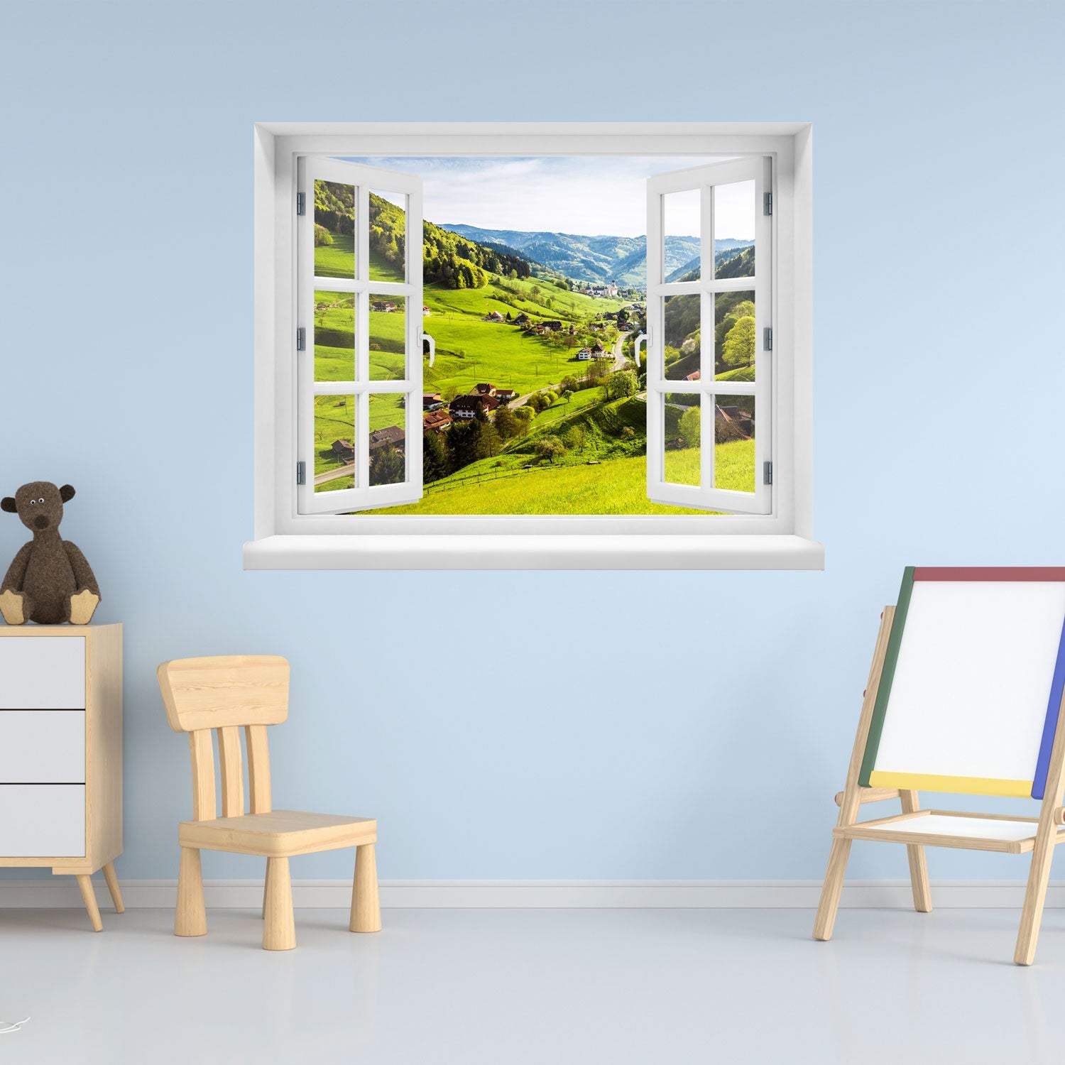 Offenes Fenster mit Ausblick auf grüne Hügel, ein idyllisches Dorf und bewaldete Berge – dekoratives Fensterbild mit realistischer 3D-Optik für naturnahes Wohnambiente. Als Dekoidee an eine blaue Wand im Kinderzimmer verklebt.
