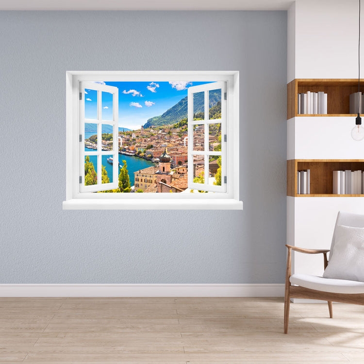 Wandsticker offenes Fenster "Dorf am See" im Wohnzimmer neben weißem Regal mit Bücher.