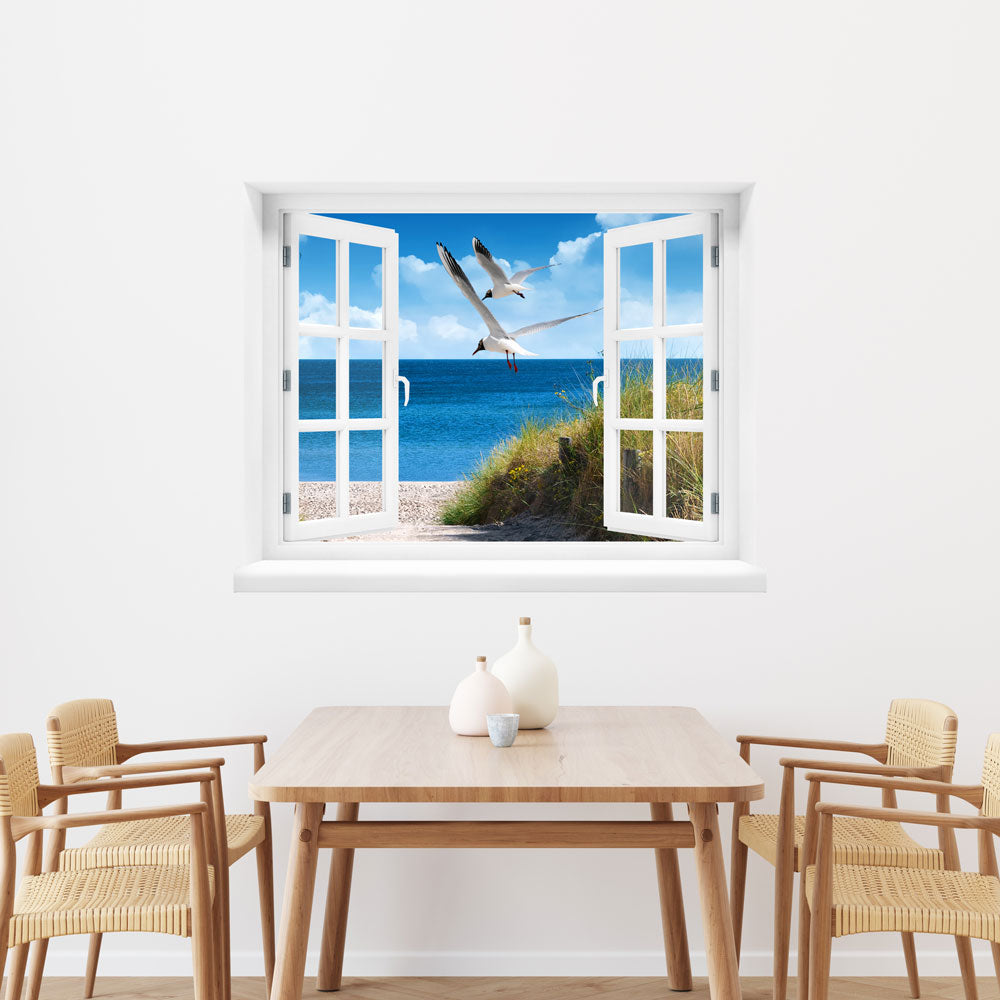 Wandaufkleber Sprossenfenster mit toller Aussicht vergrößert Zimmer optisch. Strand mit Möwen Motiv über einem Holz-Esstisch.