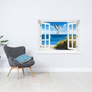 Selbstklebendes Wandbild mit schöner Aussicht auf Strand und Meer mit zwei Möwen, neben einem grauen Sessel.