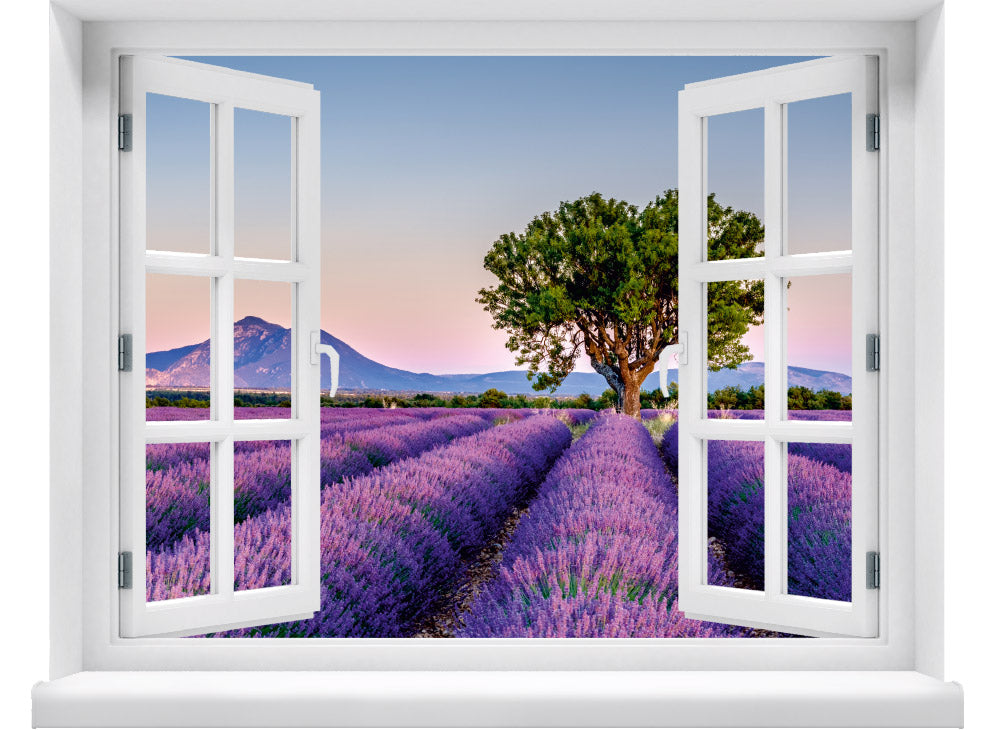 Großansicht von einem Wandaufkleber: offenes Fenster mit Blick auf ein weitläufiges Lavendelfeld bei Sonnenuntergang, mit einem markanten Baum in der Mitte und sanften Bergen im Hintergrund – romantische Landschaft in Pastellfarben.