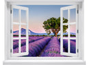 Großansicht von einem Wandaufkleber: offenes Fenster mit Blick auf ein weitläufiges Lavendelfeld bei Sonnenuntergang, mit einem markanten Baum in der Mitte und sanften Bergen im Hintergrund – romantische Landschaft in Pastellfarben.