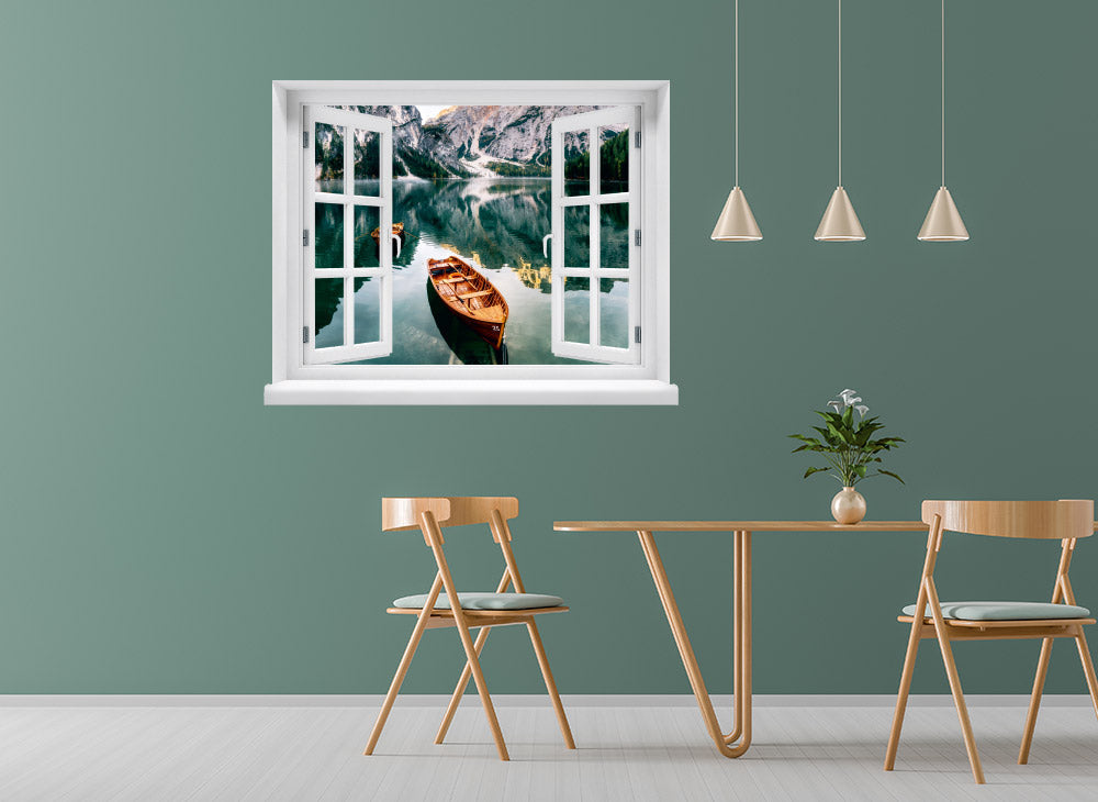 Wandaufkleber-Ansicht-offenes Fenster mit Blick auf ruhigen Bergsee mit Holzruderbooten, umgeben von steilen Felswänden und Wäldern – stimmungsvolle Naturkulisse in den Alpen. Als Dekoidee in einer Essecke an einer grünen Wand verklebt.