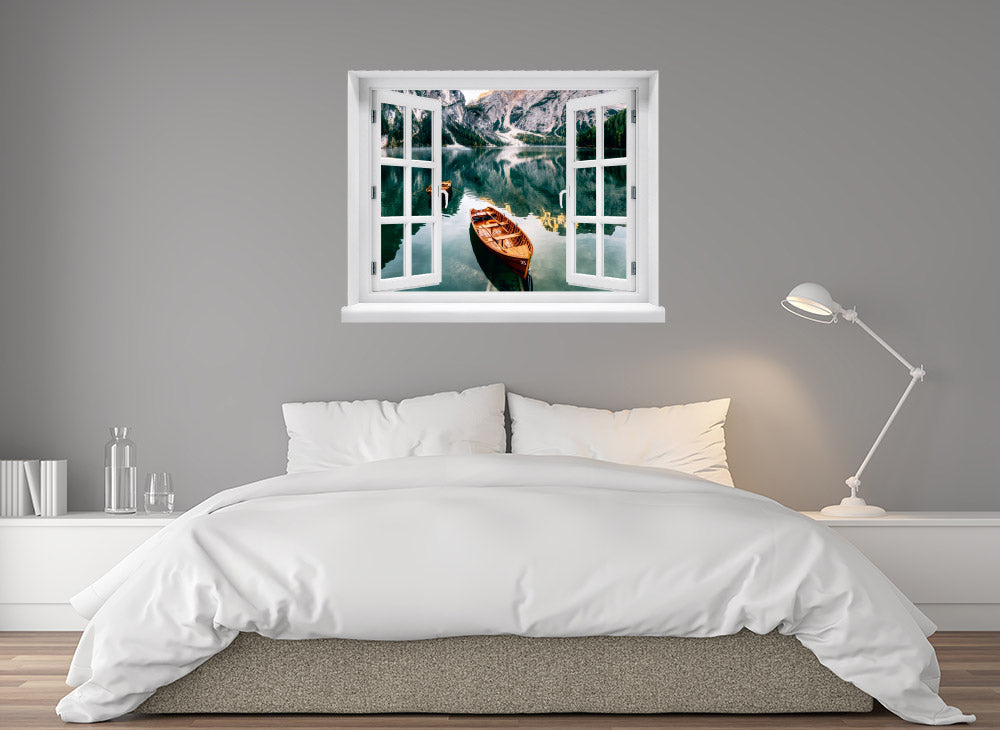 Wandaufkleber-Ansicht-offenes Fenster mit Blick auf ruhigen Bergsee mit Holzruderbooten, umgeben von steilen Felswänden und Wäldern – stimmungsvolle Naturkulisse in den Alpen. Als Dekoidee über einem Bett an einer hellgrauen Wand im Schlafzimmer verklebt.