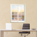 Wandtattoo bedruckt mit Fensterrahmen und tollem Naturbild "Düne und Meer" an einer gelben Wand über einem Schreibtisch im Büro.