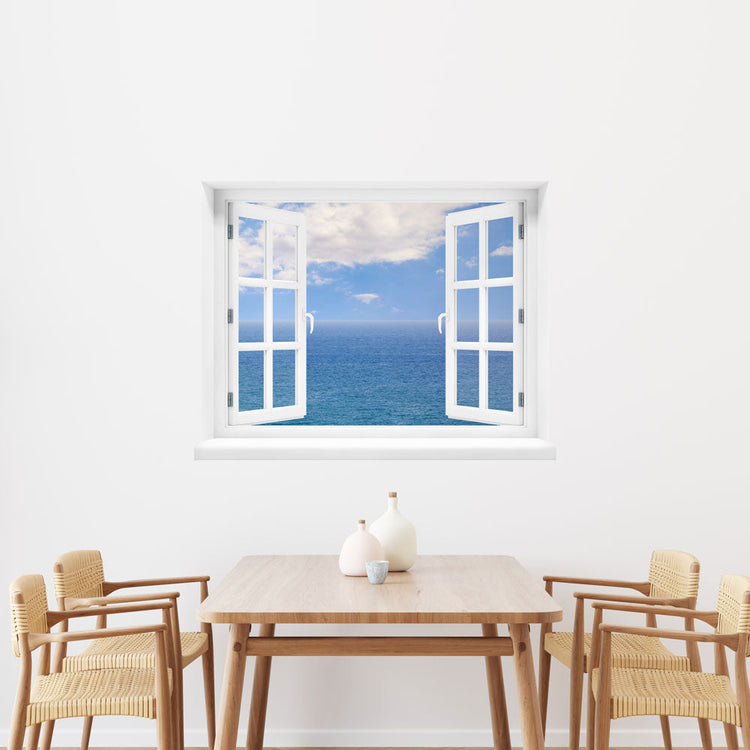 Wandaufkleber-Großansicht: offenes Fenster mit freiem Blick auf das weite, blaue Meer unter leicht bewölktem Himmel – beruhigende Meereskulisse mit Urlaubsfeeling. Als Dekoidee in einer Essecke, über dem Holztisch an einer weissen Wand verklebt.