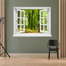 Wandaufkleber Ansicht eines offenes Fenster mit Blick in einen sonnendurchfluteten, grünen Laubwald mit einem schmalen Waldweg – entspannende Naturkulisse mit Frühlings- oder Sommerstimmung. Als Dekoidee an einer grünen Wand verklebt in einem Wartebereich.