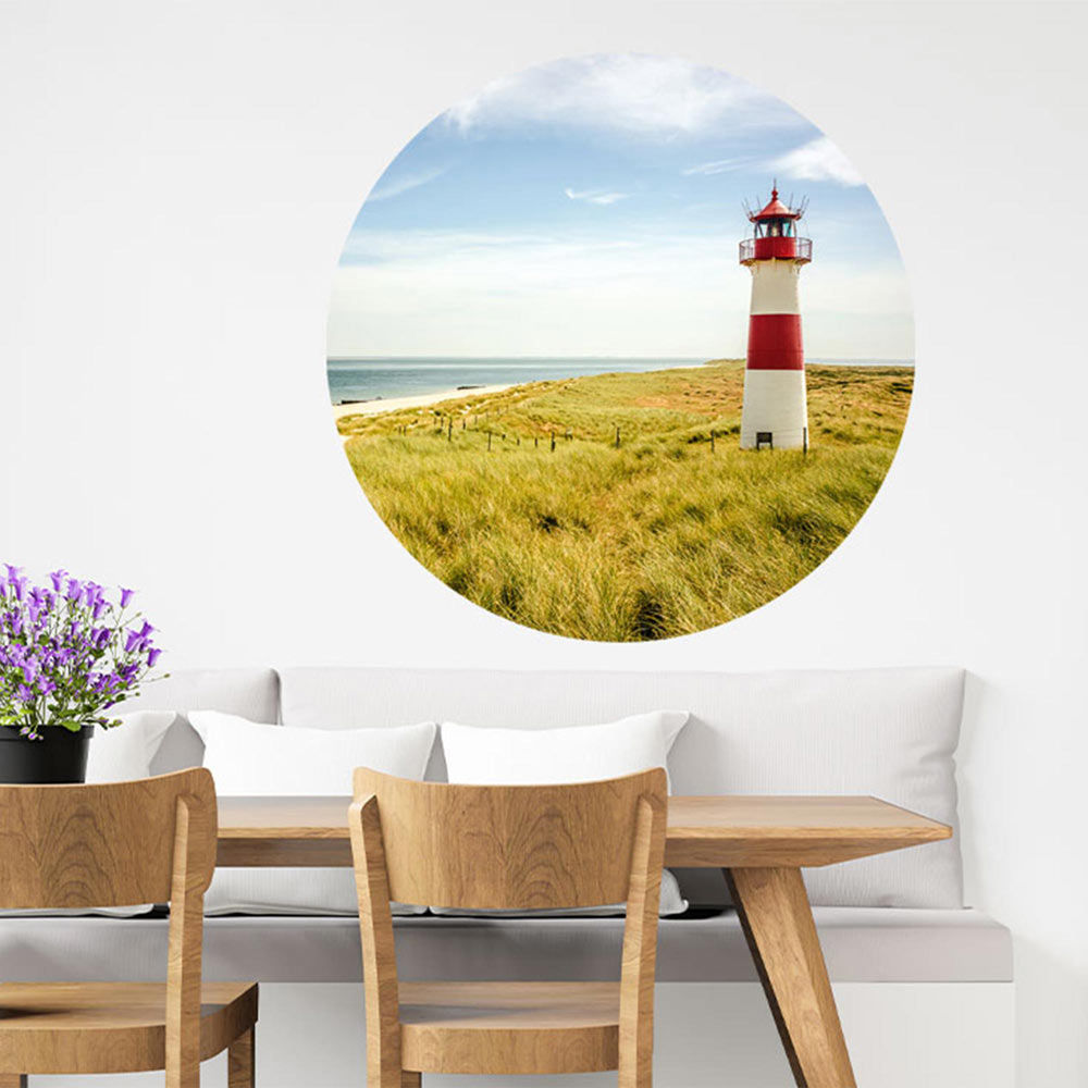 Großansicht eines runden Wandaufklebers mit dem Leuchtturm Motiv am Meer. Der Aufkleber ist als Dekoidee an eine Wand verklebt und hängt in einem Esszimmer, so bekommt der Raum eine Tiefe.