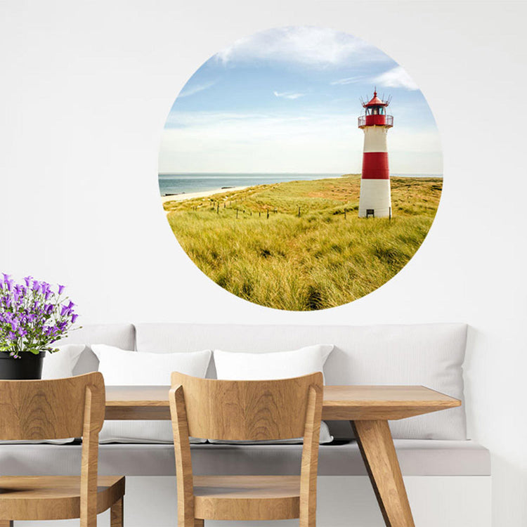 Großansicht eines runden Wandaufklebers mit dem Leuchtturm Motiv am Meer. Der Aufkleber ist als Dekoidee an eine Wand verklebt und hängt in einem Esszimmer, so bekommt der Raum eine Tiefe.