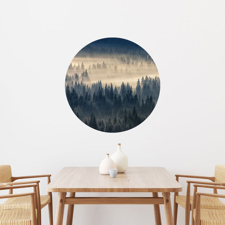 Großansicht eines runden Wandaufklebers mit einem Motiv vom Nebelwald. Das Bild schafft einen 3D Effekt und sorgt für eine Tiefe. Als Dekoidee ist es an einer weissen Wand verklebt über einem Esstisch aus Holz.